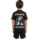 Detailaufnahme des ikonischen Ajax Vereinswappens auf dem Bob Marley Trikot. Rückansicht des schwarzen Ajax Kinder-Trikots und Shorts für den sportlichen Look.