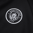 Detailaufnahme des Man City Vereinswappens auf der Trainingsjacke 25/26.